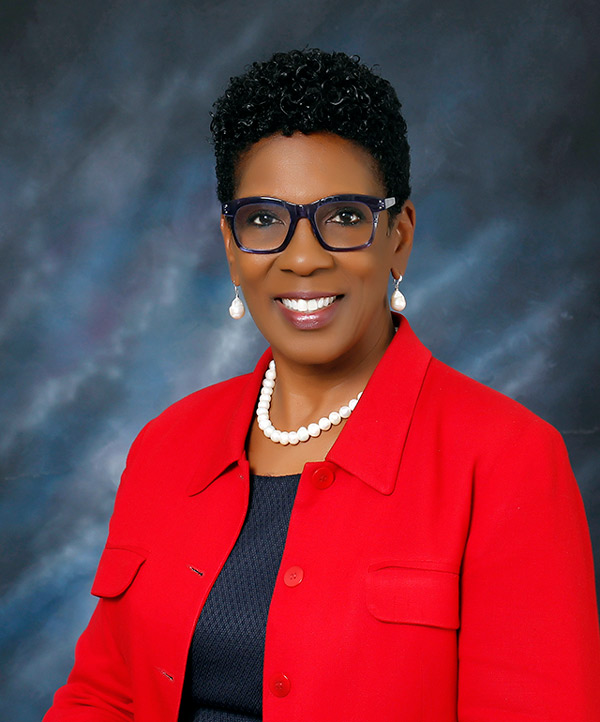 Ann Levett headshot in front of backdrop