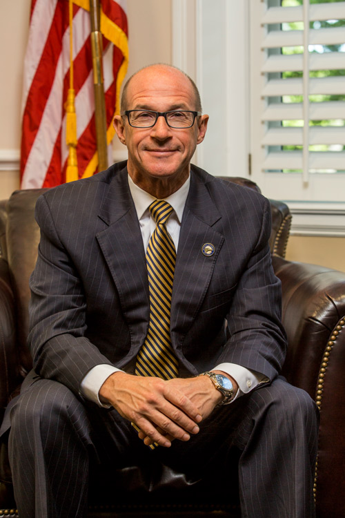 president Hebert sitting on a couch with an American flag behind him