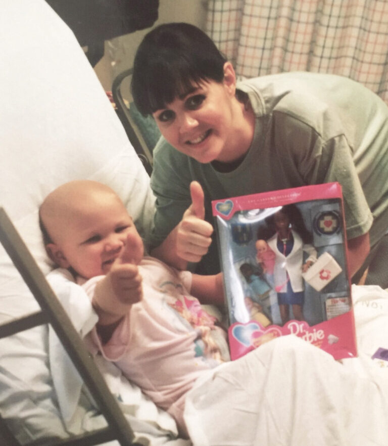 Amelia as a child in a hospital bed with no hair