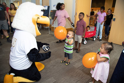 the school mascot, GUS, playing with kids