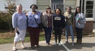 From left to right, Associate Professor of Anthropology, Heidi Altman, Ph.D., and students, Angelique Jennings, Miranda Hazelwood, Mpume Hlophe, Michaela Guilfoyle and Ahmauri Williams-Alford pose for a picture before the COVID-19 pandemic. Altman and her students have volunteered at the Willow Hill Heritage and Renaissance Center for several years.