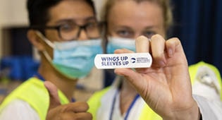 A student holds up a wings up sleeves up band aid