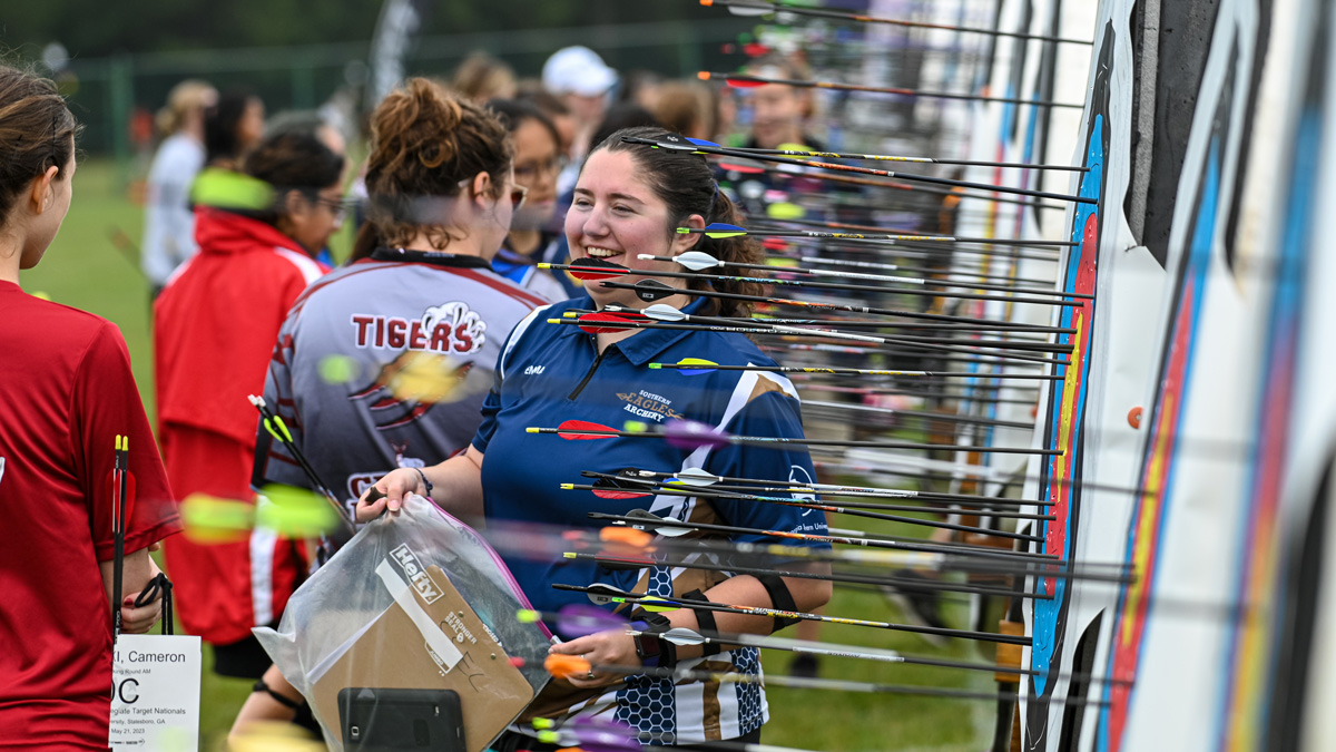 Spotter inspects arrows in targets