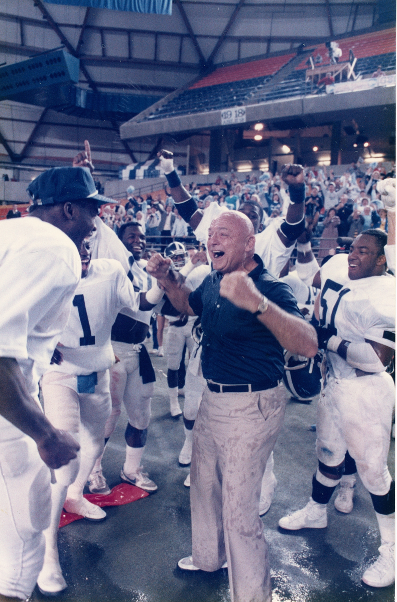 Erk Russell celebrating with Georgia Southern football players.